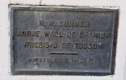 An historical plaque; clear wording reads “N. W. Corner Adobe Wall of Spanish Presidio of Tucson / Marked 1926 by D.A.R.”