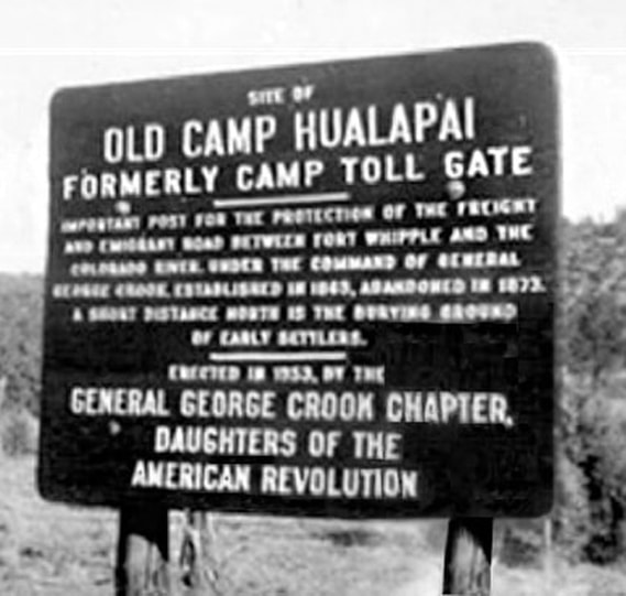 A vintage snapshot of a large sign indicating Old Camp Hualapai. Image is blurry.