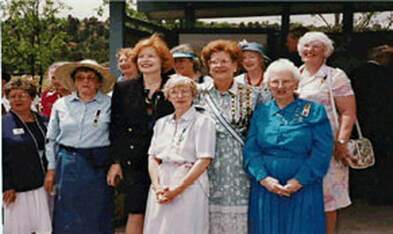 A snapshot of a group of women standing in front of an open-air kiosk with displays.