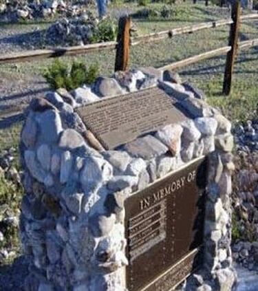 A snapshot of a concrete and stone marker for the Hardyville Pioneer Cemetery with a plaque on top; plaque text is in the body of this page. A second plaque on the front reads, “In Memory of,” and has room for names to be added.