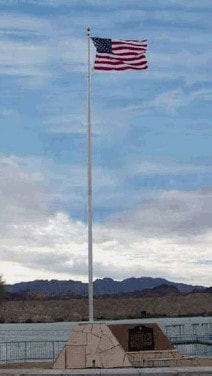 A snapshot of the marker with flagpole. The Colorado River and mountains are in the background.