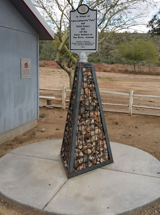 A snapshot of the marker, a wire mesh pyramid filled with river rocks with a plaque at the top.