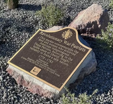 A snapshot of the America 250 marker set on a gravel bed. Marker text is in the body of this page.