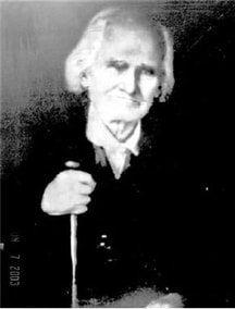 A beautiful photographic portrait of an elderly man identified as William Stewart. He is seated with his right hand holding a walking stick or cane.