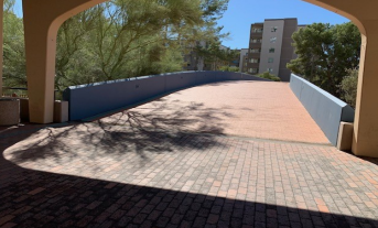 A snapshot of a curved entrance to a street bridge.