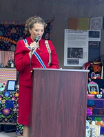 A photo showing ASDAR State Regent Sarah Ziker at the podium speaking to the audience.